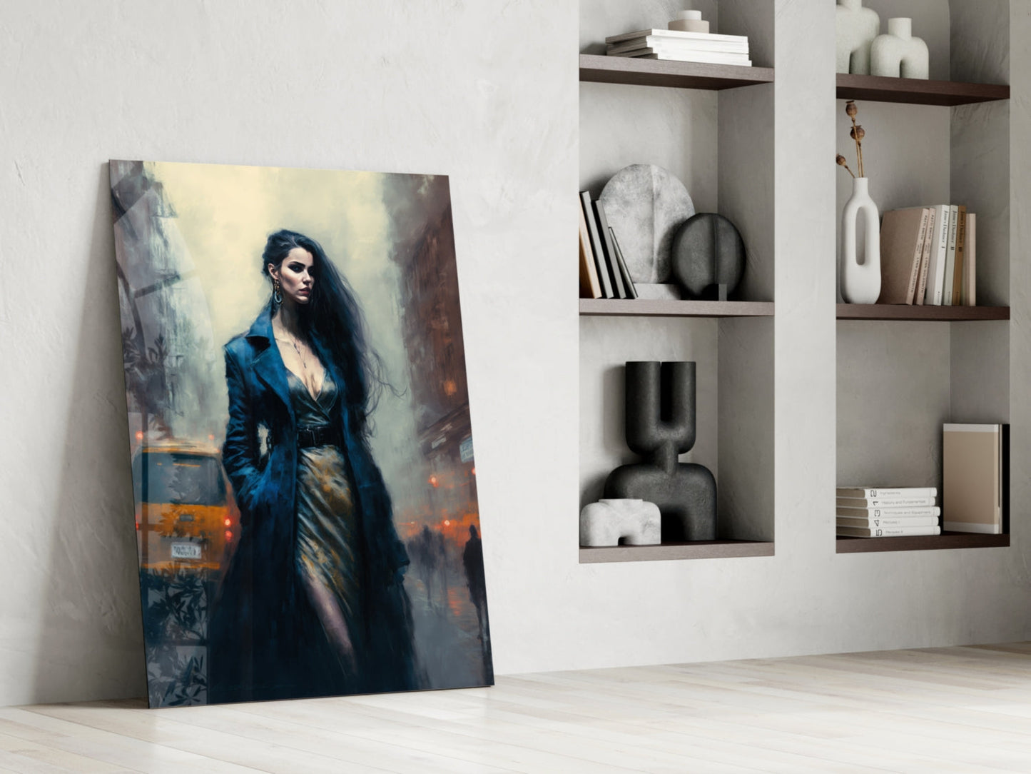 Glass wall art leaning against white wall shows woman in blue coat against urban background with warm lighting.