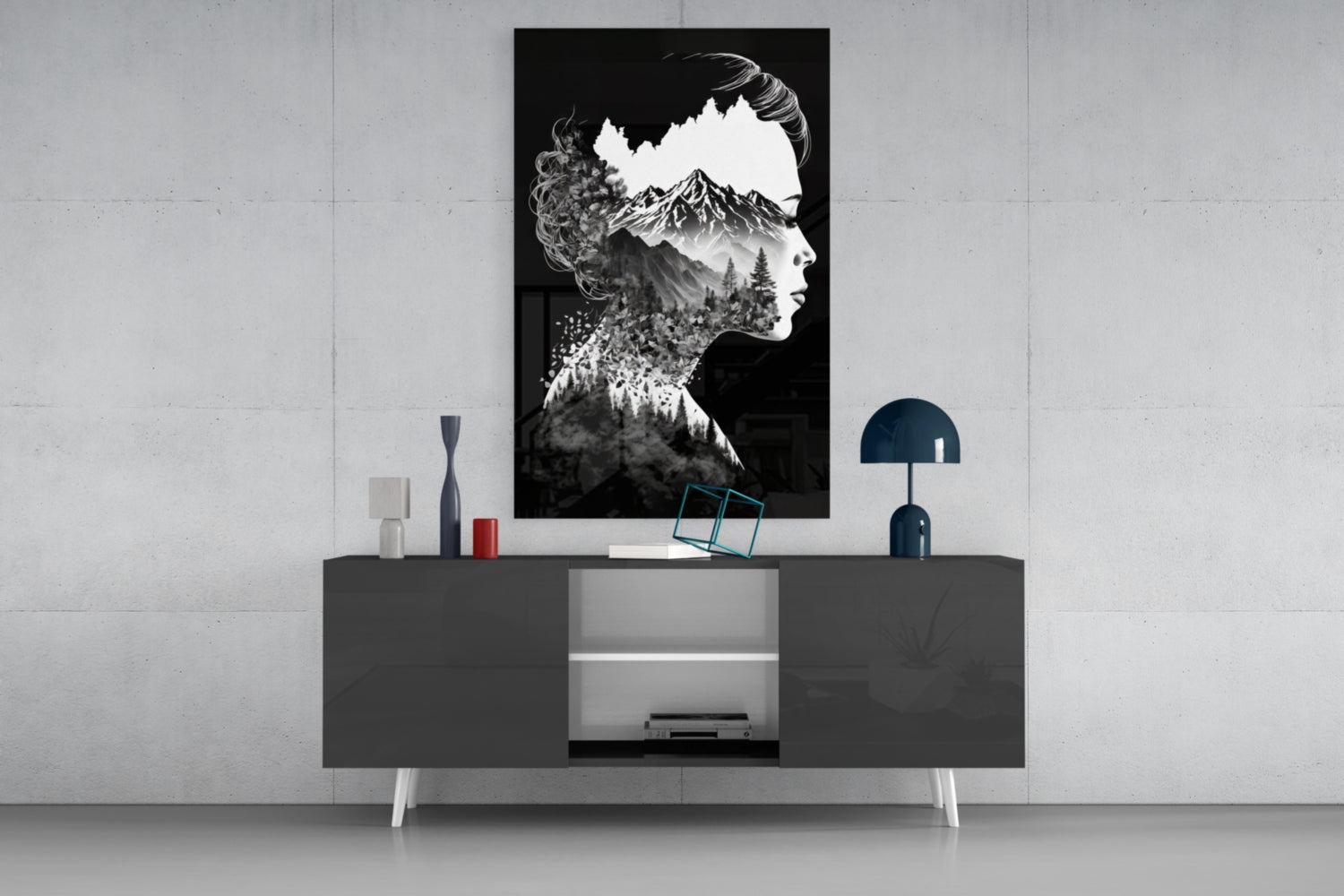 Black and white double-exposure glass wall art depicting a woman's profile silhouette filled with mountain and forest landscape, displayed above a dark console table.