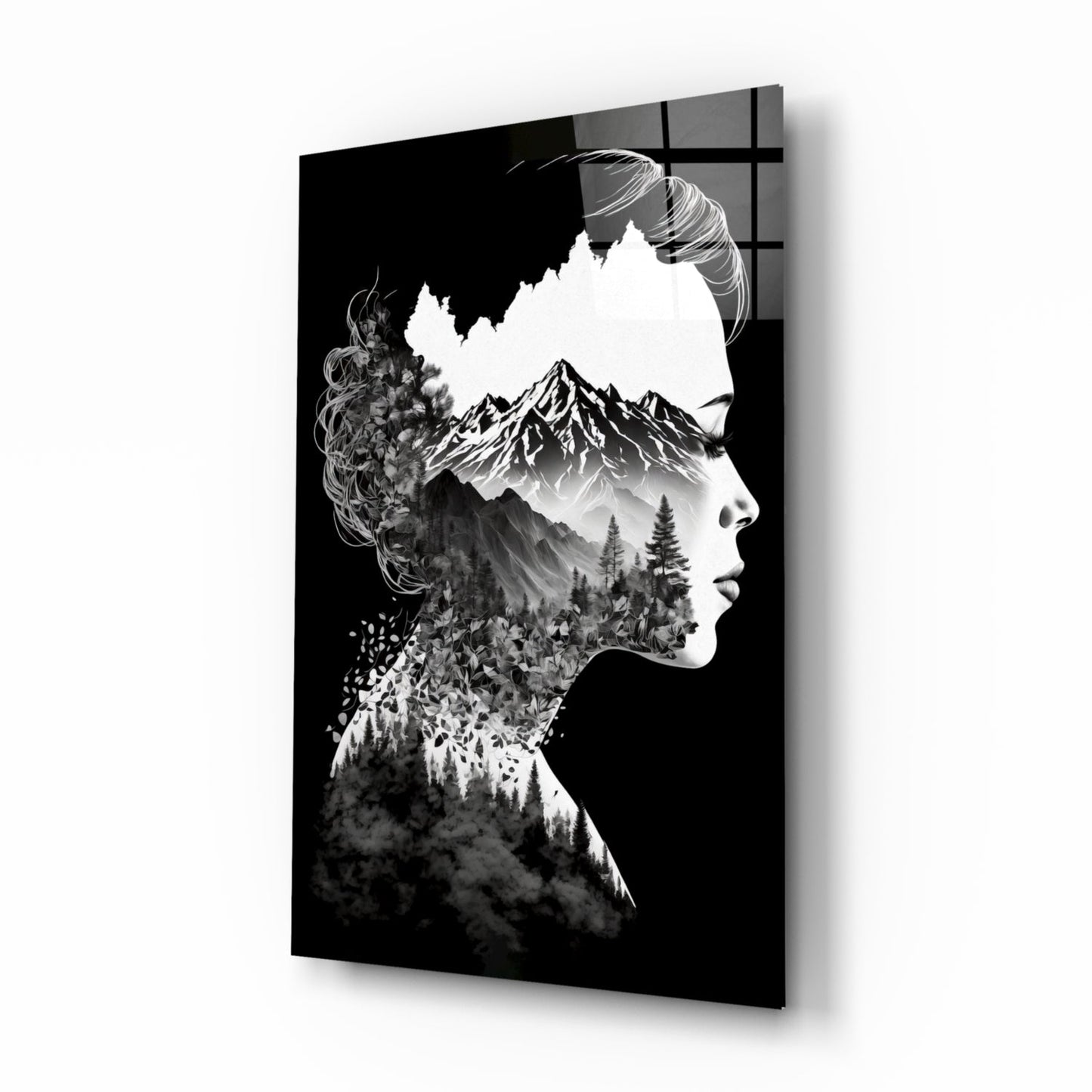 Black and white double exposure glass wall art showing a woman's profile with mountains and forest layered within her silhouette against dark background.