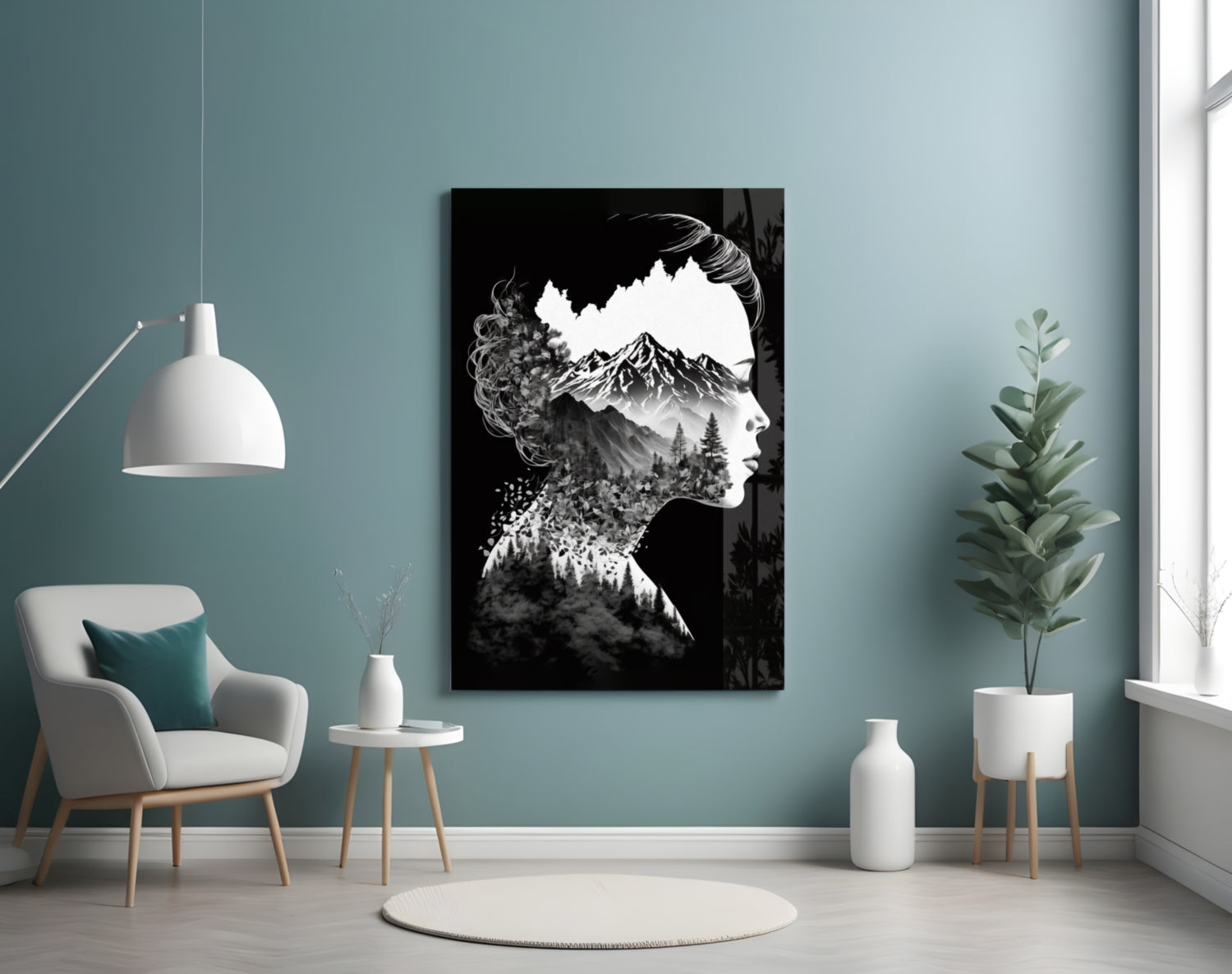 Black and white glass wall art featuring a woman's profile with mountain and forest imagery inside her silhouette, displayed in a styled room with turquoise walls.