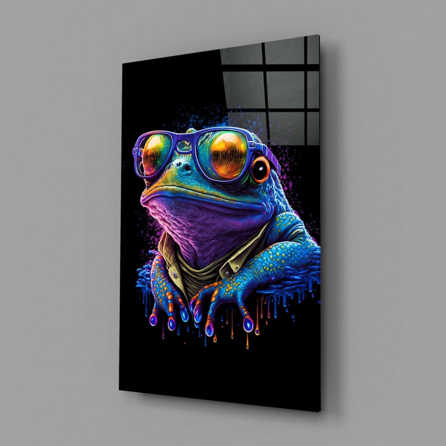 Angled view of black glass wall art featuring a neon-colored frog wearing sunglasses and bandana against dark background.