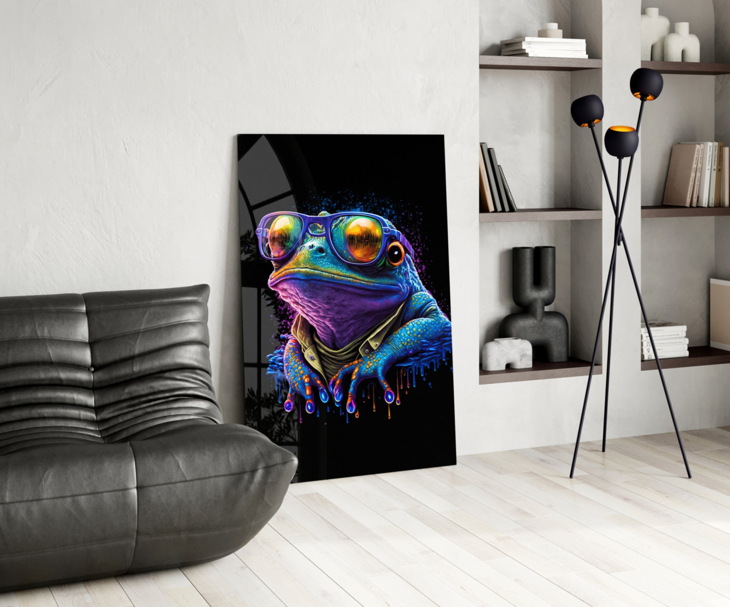 Vibrant neon frog wearing sunglasses displayed as glass wall art in modern living room setting with gray sofa and shelving.