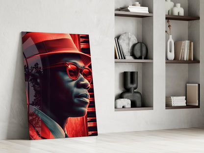 Red neon-lit glass art panel featuring a stylized face with sunglasses, leaning against white wall beside floating shelves with decorative objects.