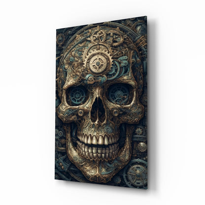 Steampunk-style glass wall art displaying an ornate brass skull with mechanical gears in the eye sockets, shown at an angle against a dark background.