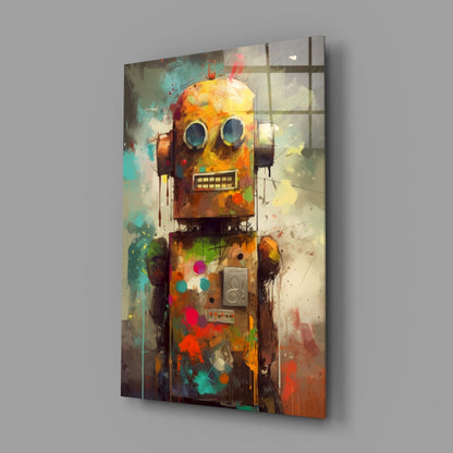 Angled view of a glass wall art panel featuring a colorful robot character with large round eyes and geometric shapes in orange, yellow, turquoise, and red tones.
