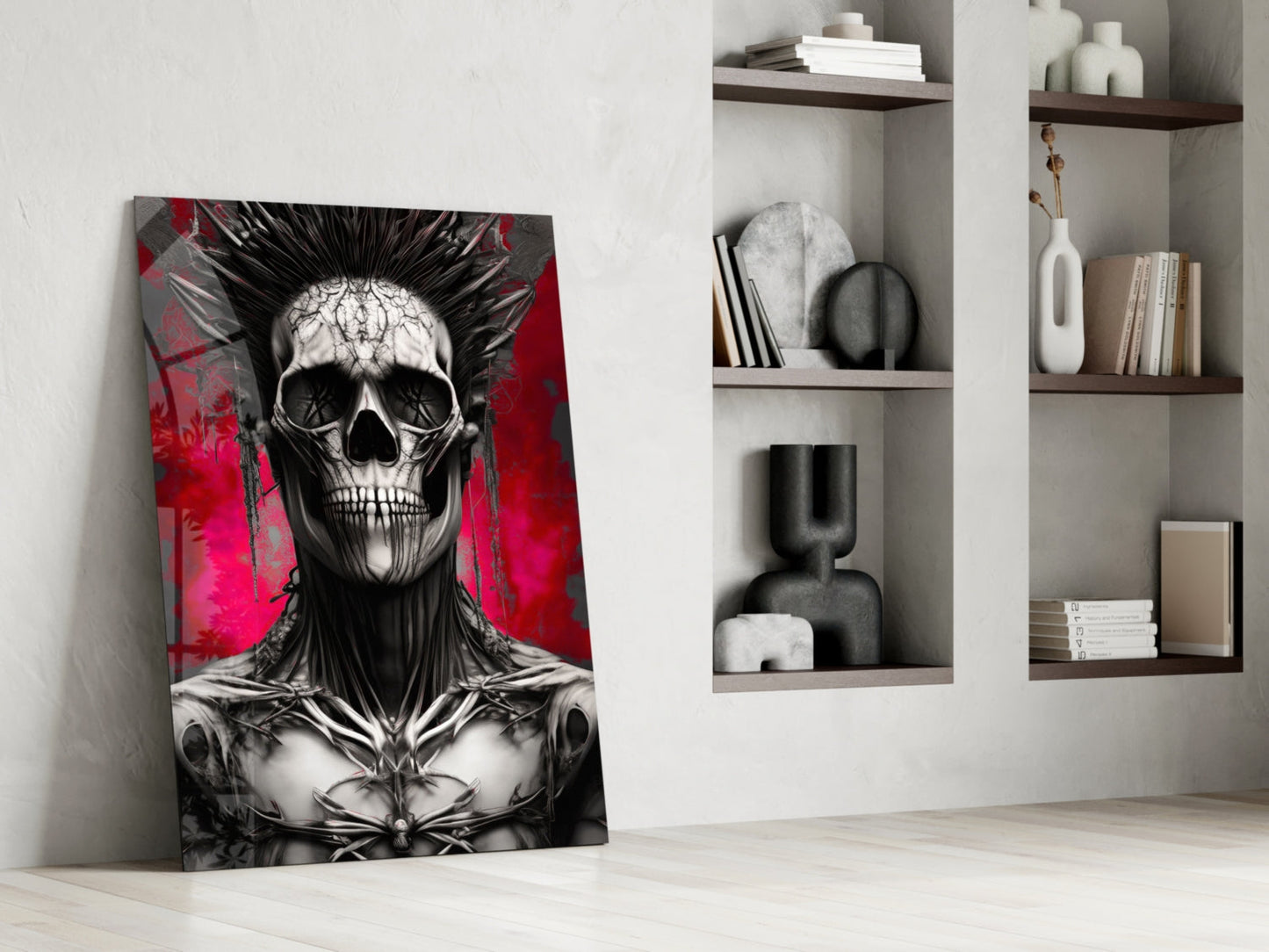 Leaning glass wall art featuring black and white skull with spiky hair against vibrant red and magenta background, displayed in modern white room with wooden shelves.