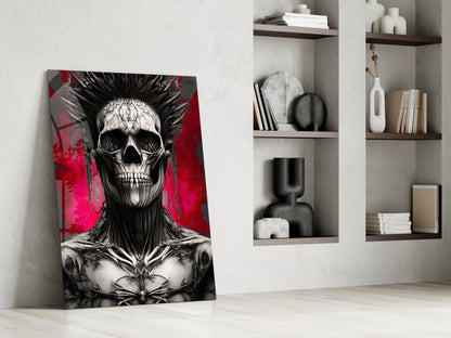 Leaning glass wall art featuring black and white skull with spiky hair against vibrant red and magenta background, displayed in modern white room with wooden shelves.