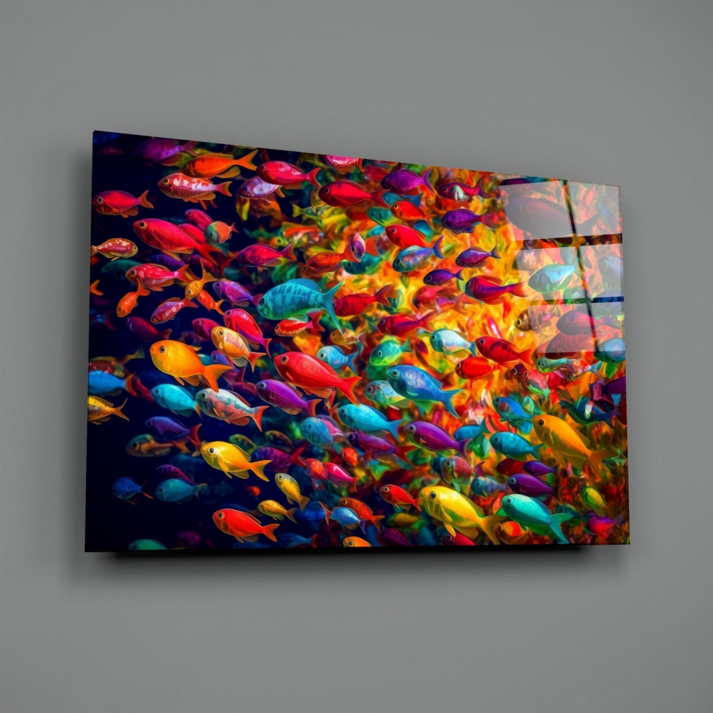 Angled view of glass wall art displaying a vibrant school of multicolored tropical fish swimming against a dark background.