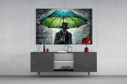 Modern living room display showing glass wall art above gray media console, featuring silhouetted figure with neon green and blue umbrella against textured background.