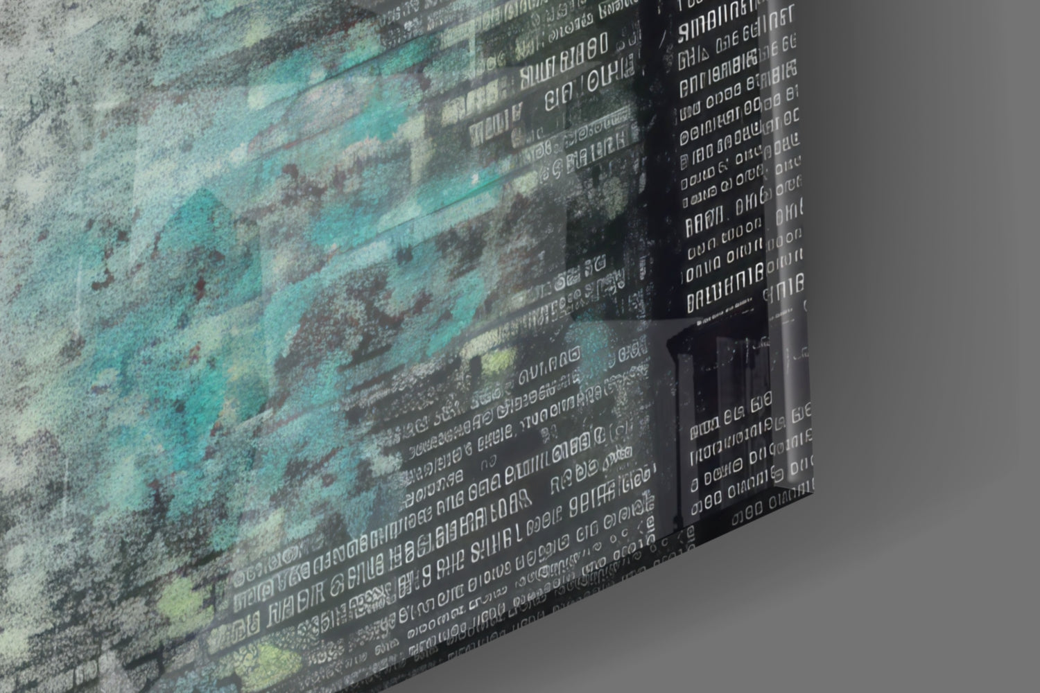Close-up angled view of glass wall art showing layered turquoise and gray textures with overlaid white text, photographed from the side to display depth and transparency.