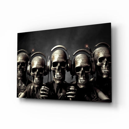 Five metallic skulls wearing headphones arranged in a row against a dark background, displayed as a glass wall art panel.