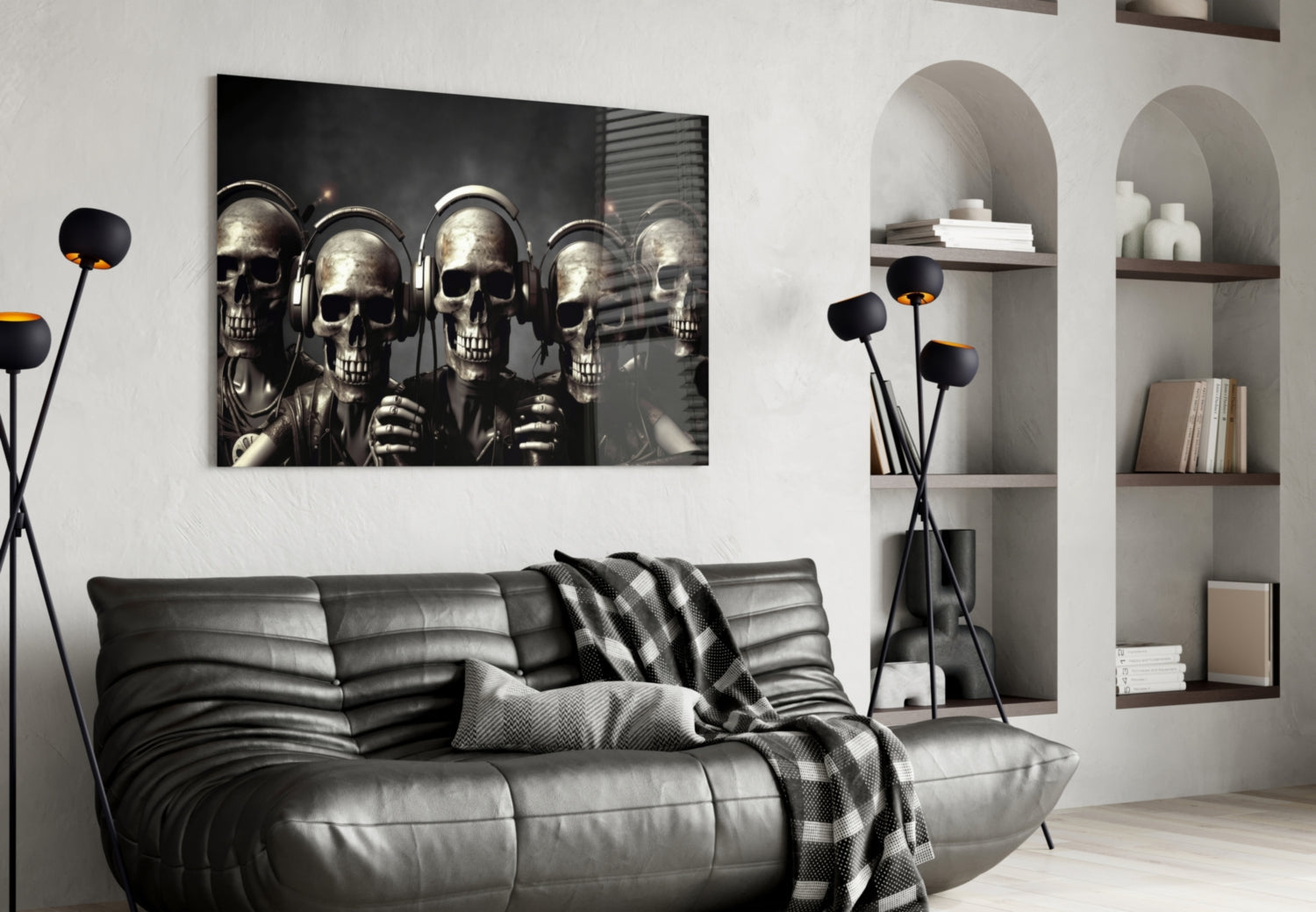 Black and white glass wall art featuring five skulls wearing headphones displayed above a gray leather sofa in a modern living room.