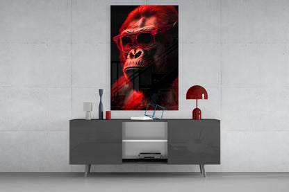 Red-lit gorilla wearing sunglasses displayed as wall art above gray media console with red lamp and decorative accessories.