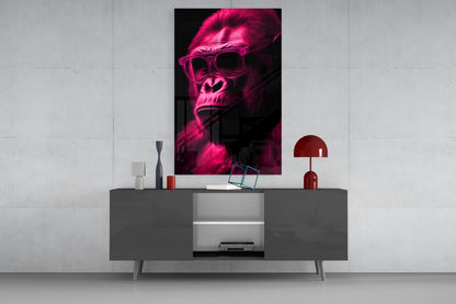 Neon pink glowing gorilla wearing sunglasses displayed as wall art above gray media console with red lamp and decorative objects.