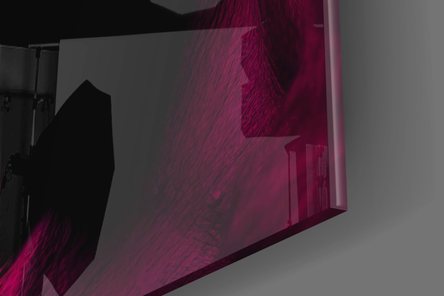 Angled side view of magenta and burgundy glass wall art with textured surface and silhouetted figure, mounted on gray wall.