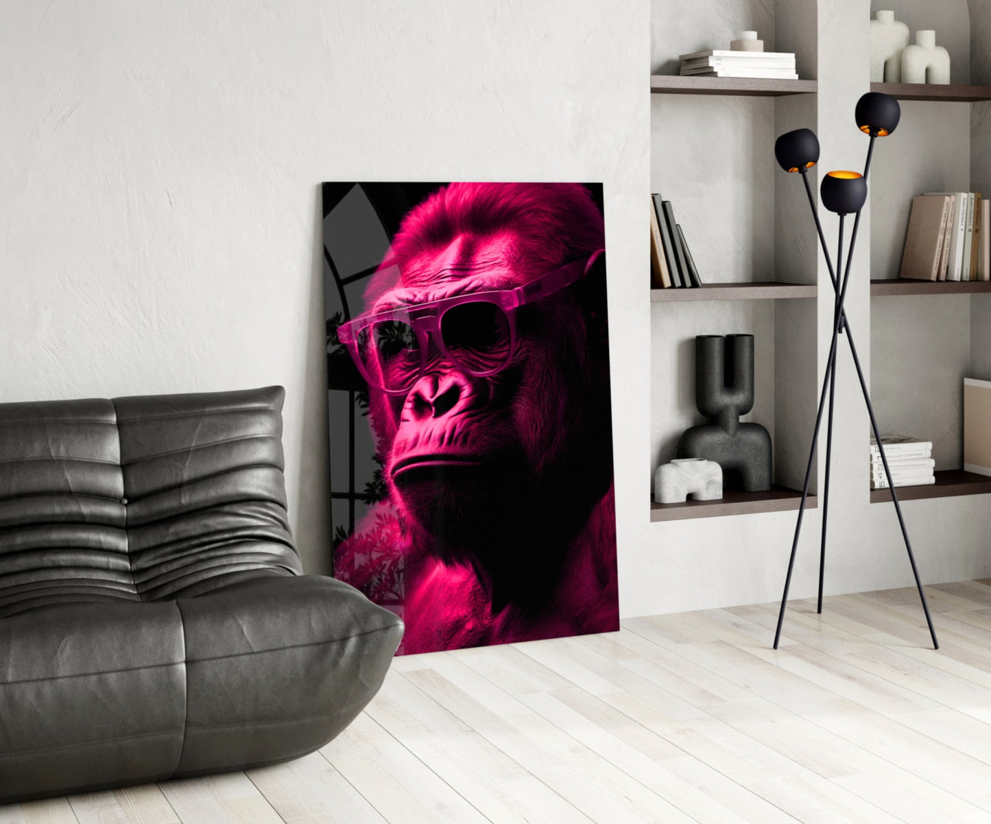 Neon pink and black glass wall art depicting a sunglasses-wearing ape displayed in modern living room with gray sofa and shelving.