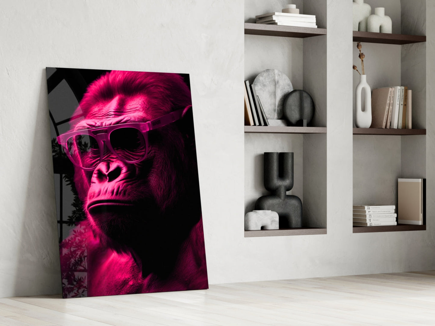 Neon pink and black gorilla wearing sunglasses glass wall art leaning against white wall beside shelving unit.