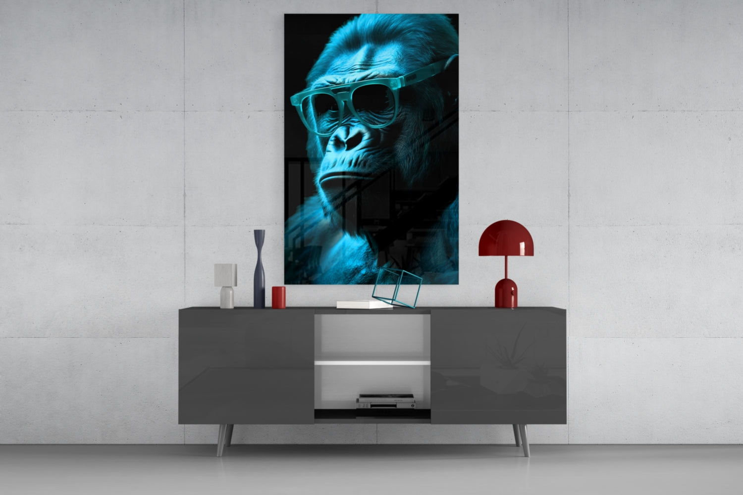 Blue-tinted gorilla wearing sunglasses displayed as framed glass wall art above a dark console table with red lamp and decorative objects.