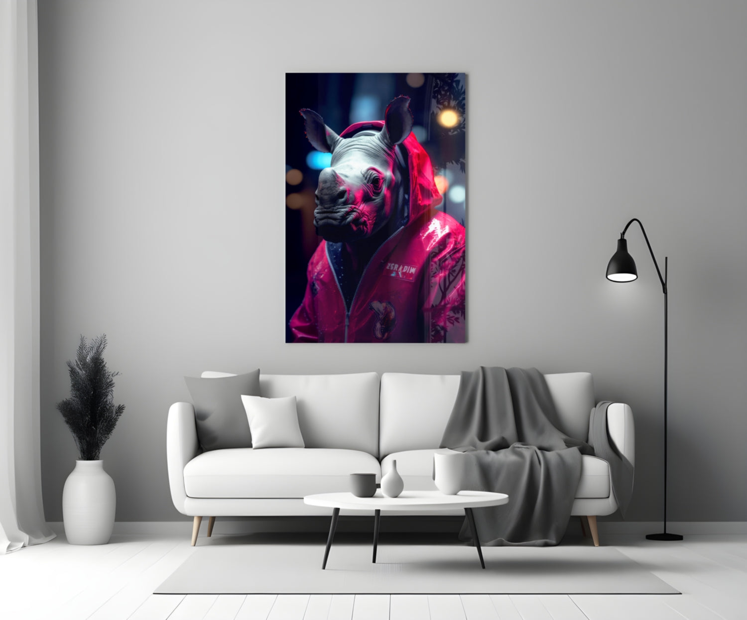 Neon-lit rhino wearing hot pink jacket displayed on white living room wall above gray sofa.