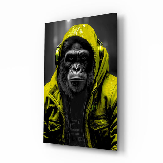 Angled three-quarter view of glass wall art showing a chimpanzee wearing a bright yellow raincoat and headphones against a dark background.