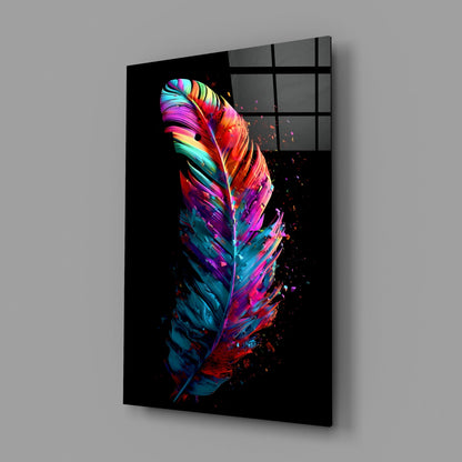 Angled perspective view of vibrant neon feather glass wall art on black background, showing colorful gradient stripes in pink, blue, yellow, and red with particle effects.