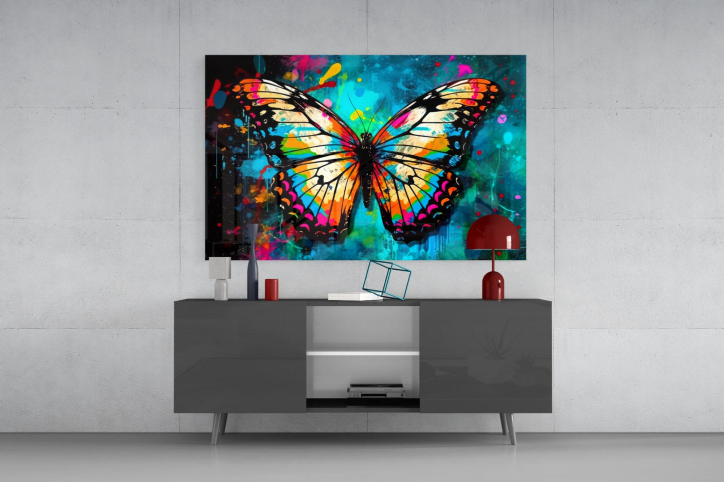 Colorful butterfly glass wall art with orange, yellow, blue, and magenta wings displayed above a gray media console in a modern interior setting.