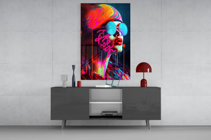 Vibrant neon pop art glass wall art featuring a figure with cyan sunglasses and magenta text displayed above a dark console table.