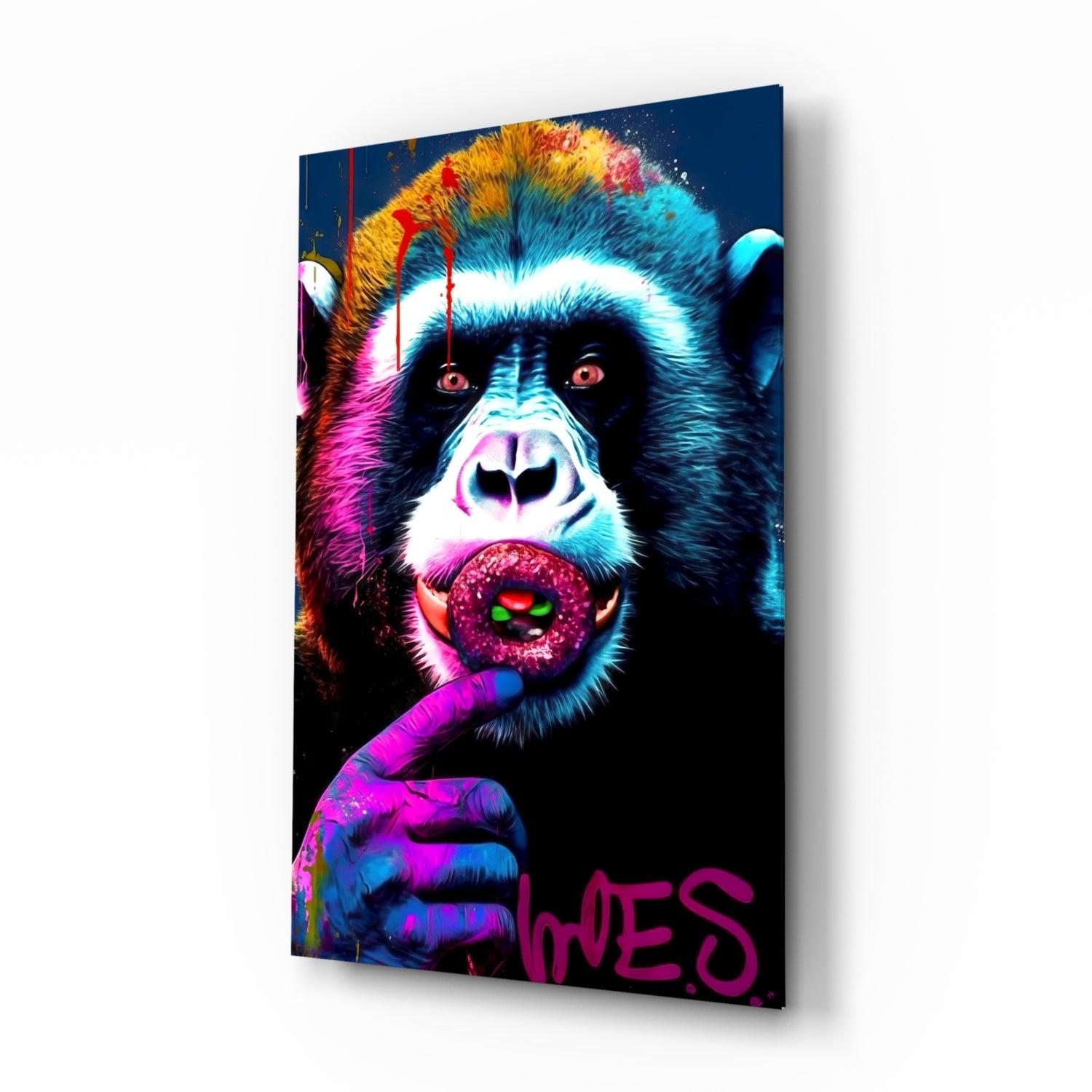 Angled view of a colorful glass wall art panel featuring a vibrant neon-style chimp holding a lollipop with magenta text at bottom right.