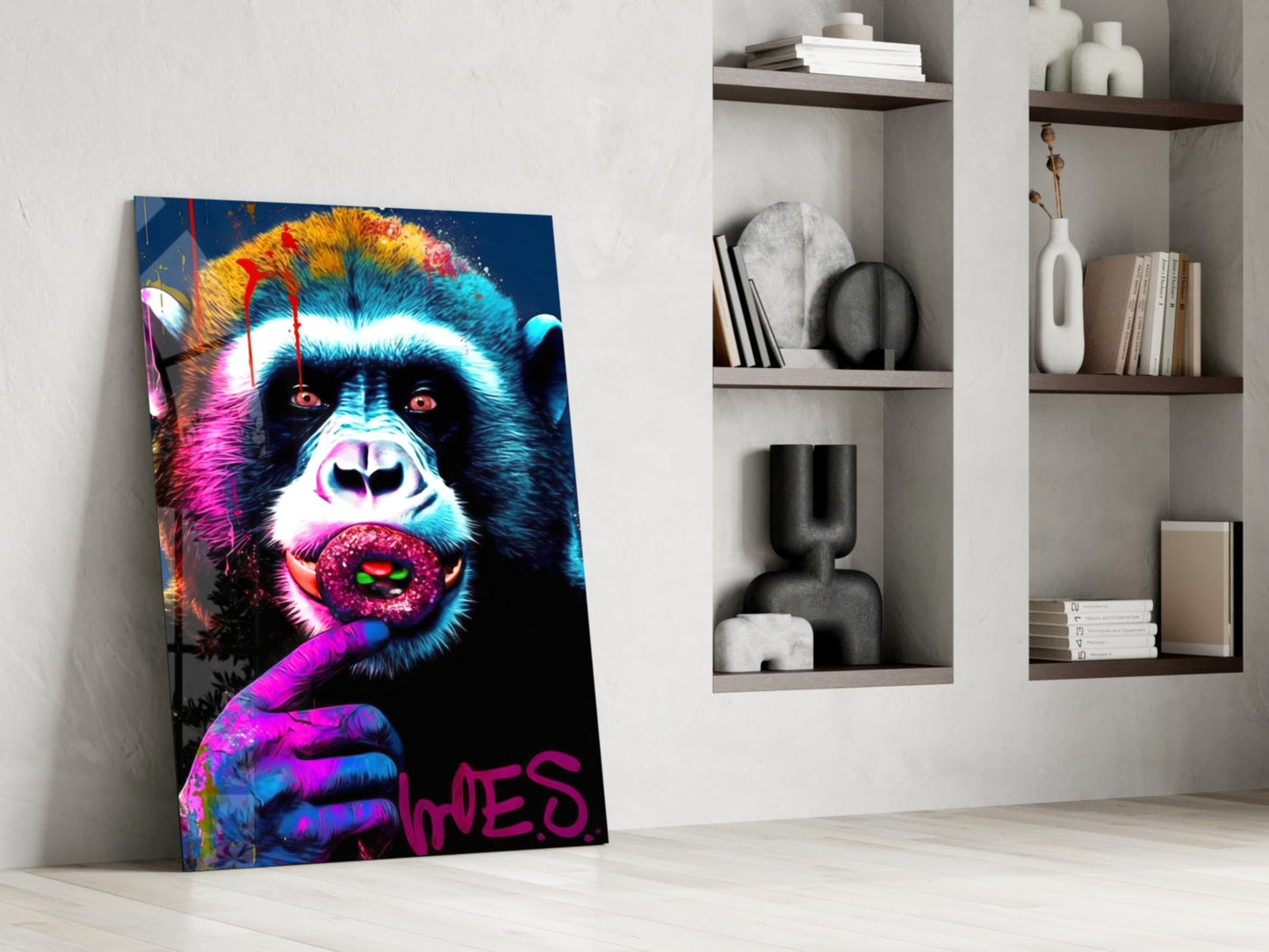 Vibrant neon pop art canvas of a colorful monkey with pink lips leaning against white wall shelving displaying books and decorative objects.