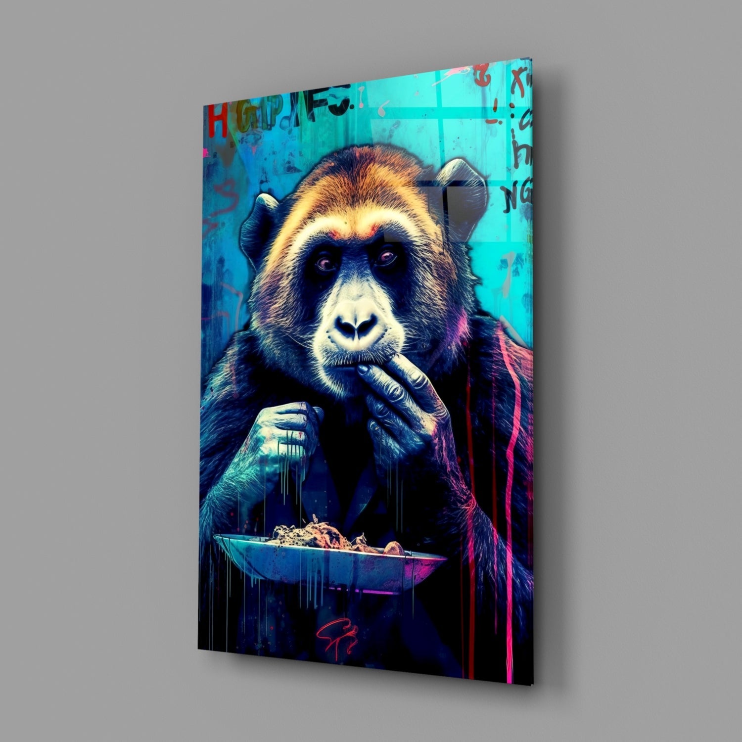 Angled view of glass wall art depicting a colorful chimpanzee holding a bowl, vibrant turquoise and neon backgrounds, mounted on gray surface.