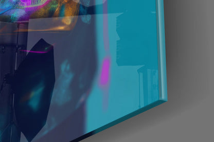 Angled view of turquoise glass wall art panel displaying colorful abstract design with magenta and gold accents.