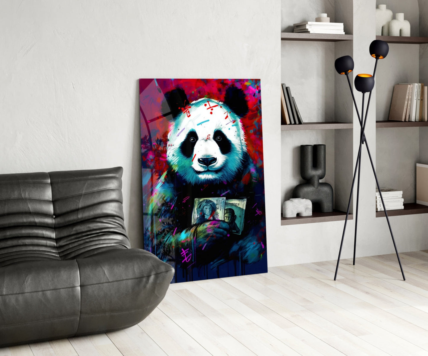 Vibrant pop art panda holding money artwork displayed on gallery wall beside gray leather chair and shelving unit.
