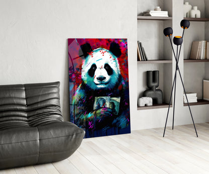 Vibrant pop art panda holding money artwork displayed on gallery wall beside gray leather chair and shelving unit.