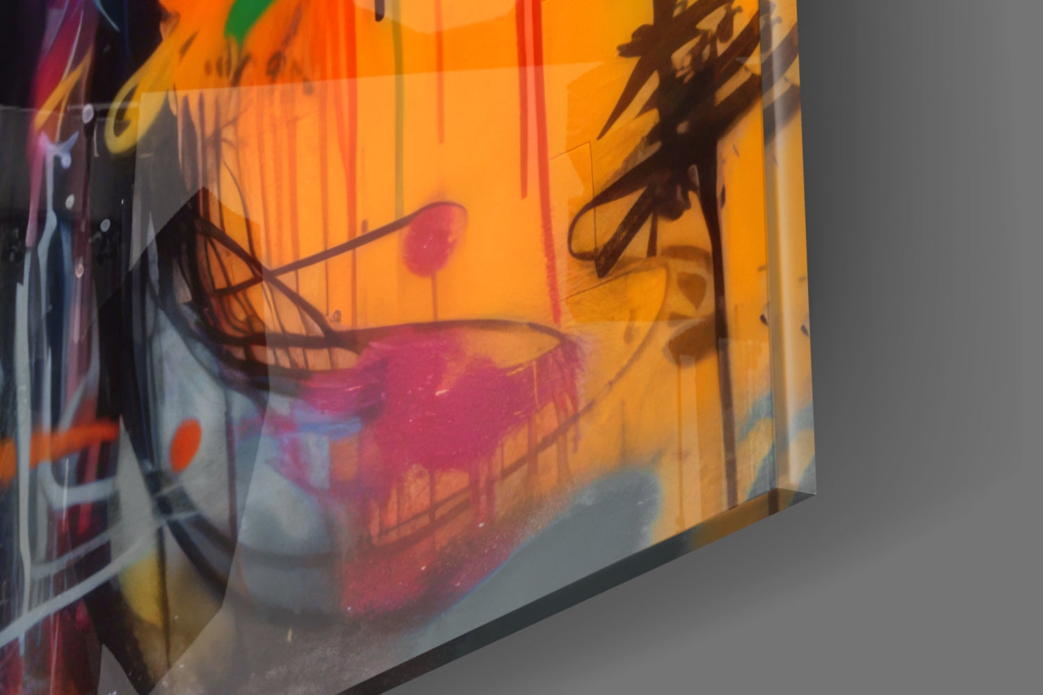 Close-up angled view of glass wall art displaying abstract red and pink figures against orange and yellow striped background with brown line details.