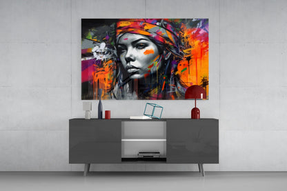 Colorful street art portrait of a woman with vibrant paint splashes displayed above a dark gray media console in a modern interior setting.