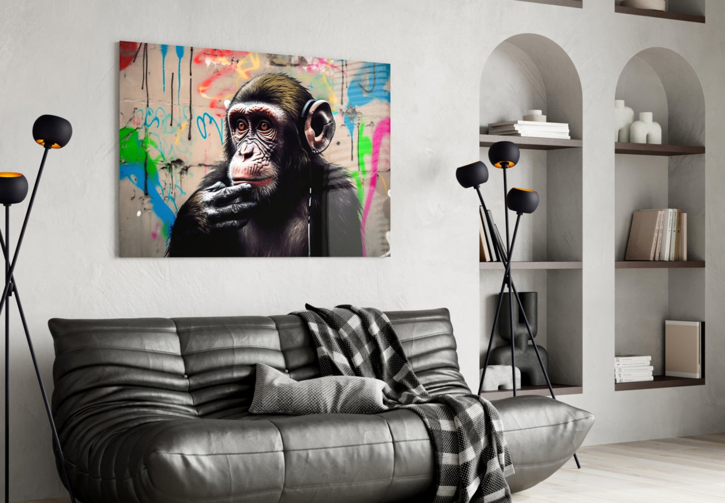 Thinking Monkey glass wall art hung above grey leather sofa in modern living room with white shelving and black floor lamp.