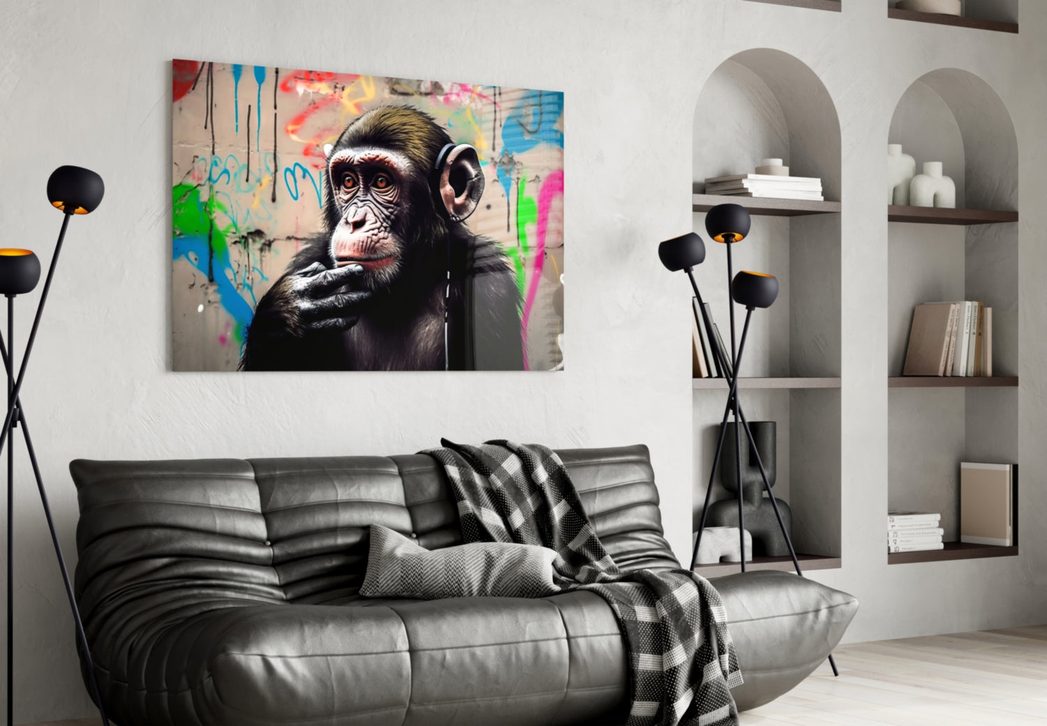 Thinking Monkey glass wall art hung above grey leather sofa in modern living room with white shelving and black floor lamp.