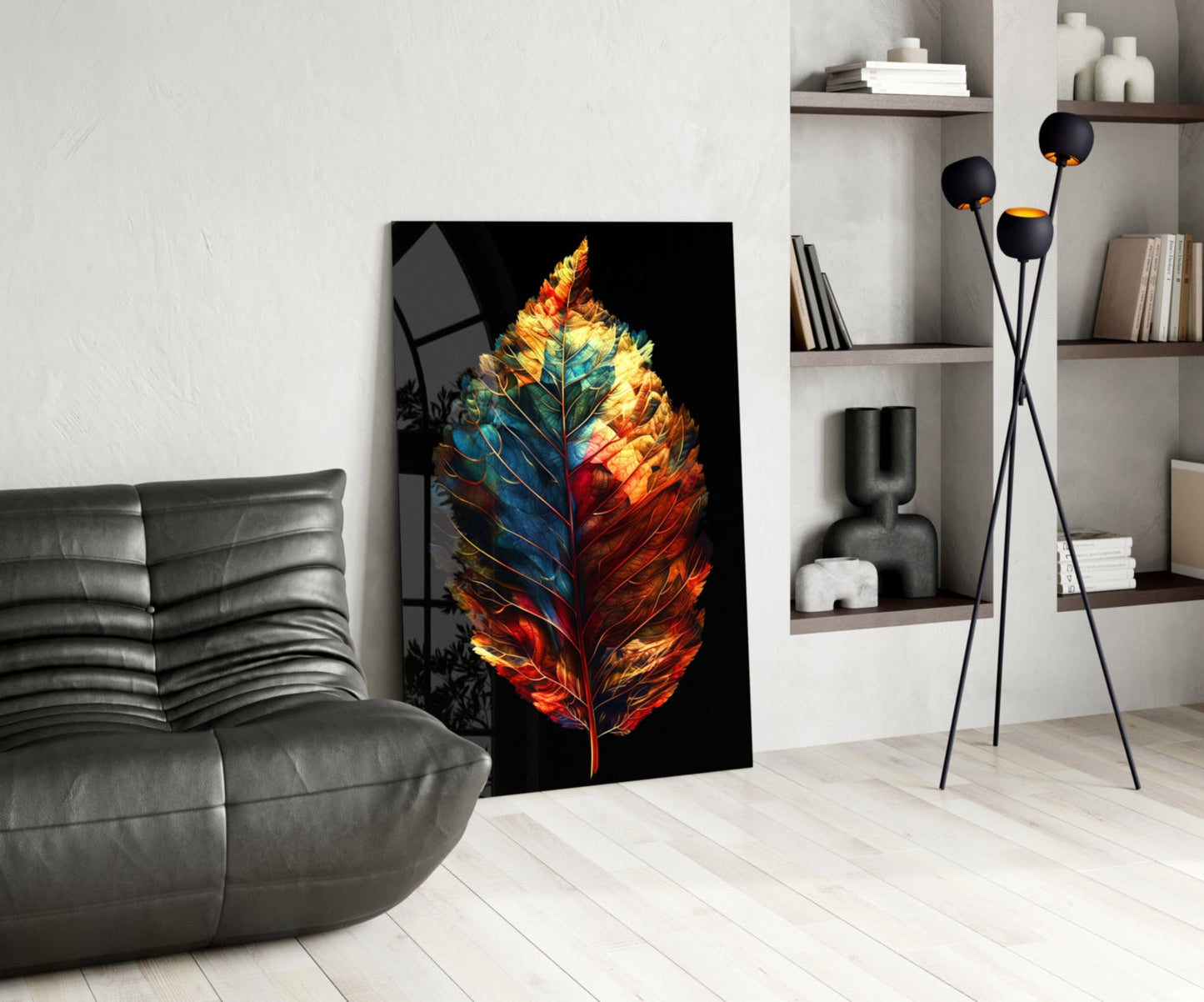 Colorful glass leaf artwork with red, orange, yellow, and blue tones leaning against wall in modern living room interior.