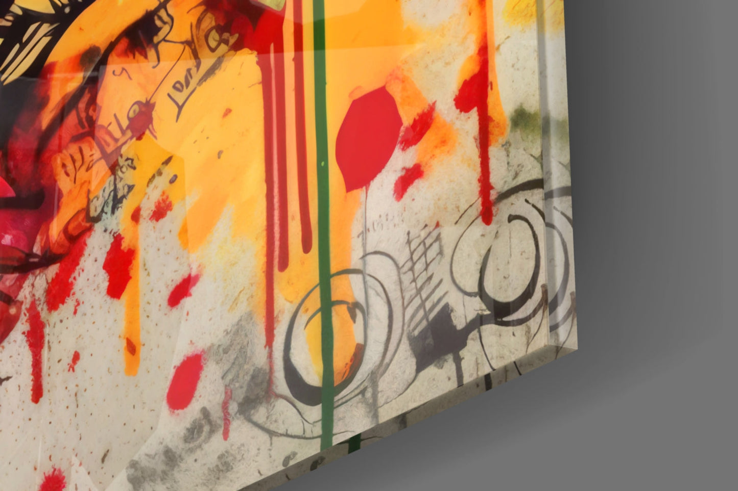 Close-up angled view of glass wall art showing red and orange paint splatters, green and red vertical stripes, and sketched circular designs on white surface.