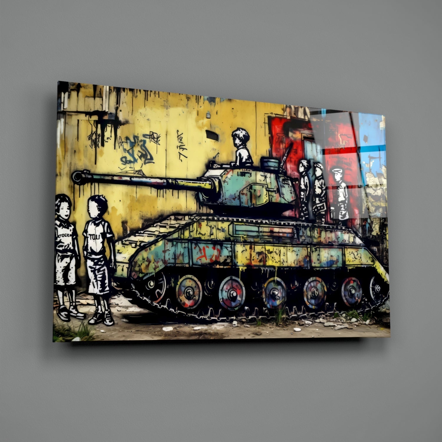 Glass wall art print displayed at slight angle against gray wall, showing street art mural of two children watching a tank on yellow brick wall background.