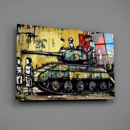 Glass wall art print displayed at slight angle against gray wall, showing street art mural of two children watching a tank on yellow brick wall background.