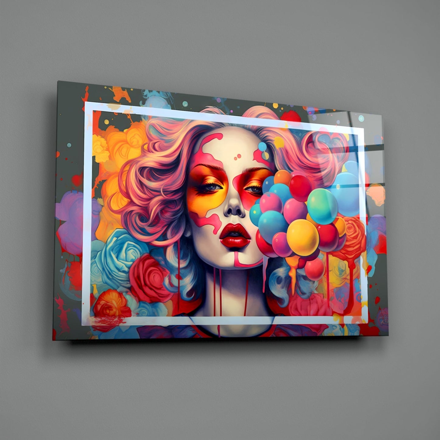 Colorful glass wall art mounted on gray wall showing portrait of woman with pink hair, vibrant flowers, and multicolored balloons in dynamic pop art style.