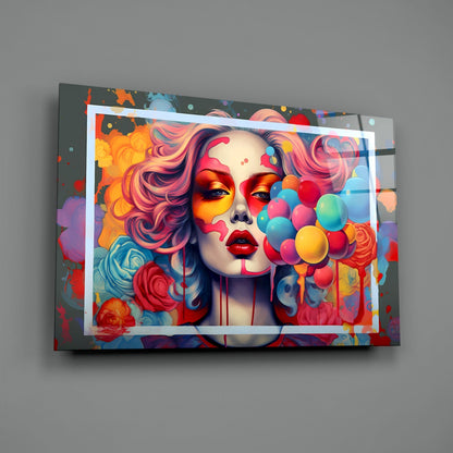 Colorful glass wall art mounted on gray wall showing portrait of woman with pink hair, vibrant flowers, and multicolored balloons in dynamic pop art style.