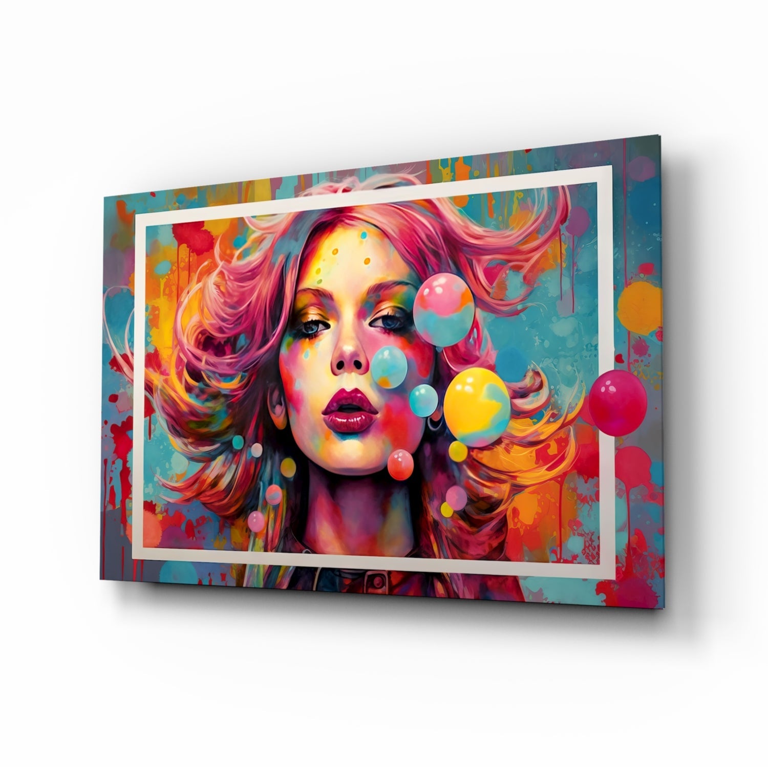 Angled view of colorful glass wall art featuring a woman's portrait with vibrant pink hair, rainbow-painted face, floating bubbles, and white frame border against multicolored abstract background.