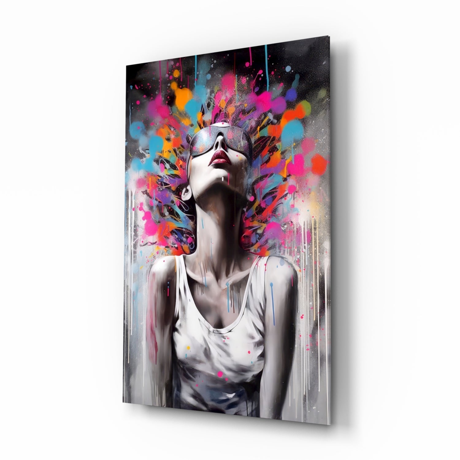 Glass wall art panel displayed at an angle showing a figure in sunglasses with colorful paint splatters exploding from head against white shirt.