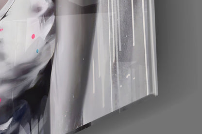 Close-up angled view of glass wall art showing vertical white streaks and colored dots (pink and blue) on translucent glass surface.