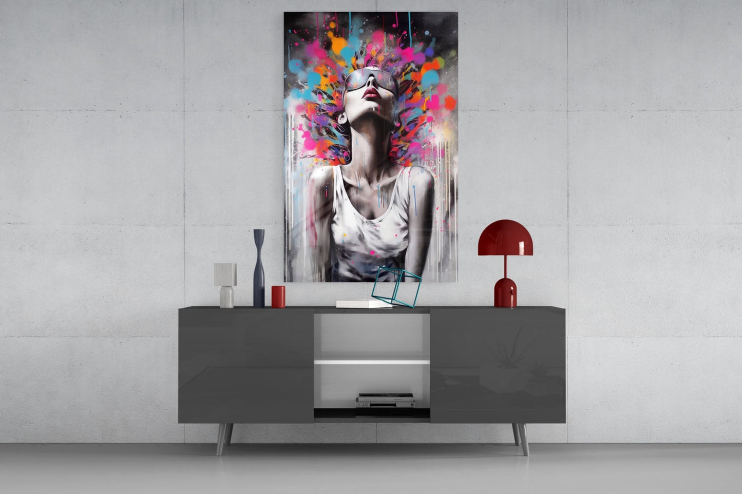 Colorful abstract glass wall art depicting a woman with vibrant paint splashes displayed above a dark modern console table.