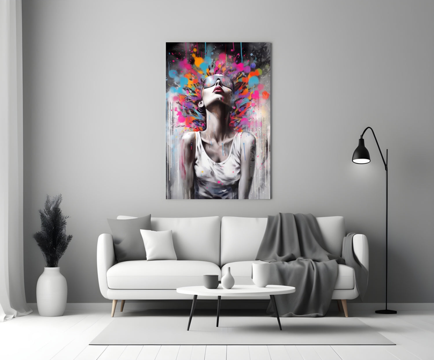 Colorful glass wall art depicting a woman with sunglasses and vibrant paint splashes above her head, displayed above a white sofa in a minimalist living room.
