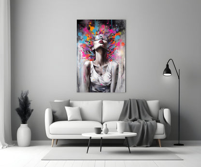 Colorful glass wall art depicting a woman with sunglasses and vibrant paint splashes above her head, displayed above a white sofa in a minimalist living room.