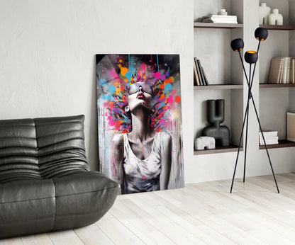 Modern living room interior with colorful abstract portrait glass art leaning against wall beside black leather sofa.